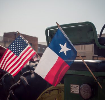 "Commercial semi-truck driving on Texas highway near urban skyline"