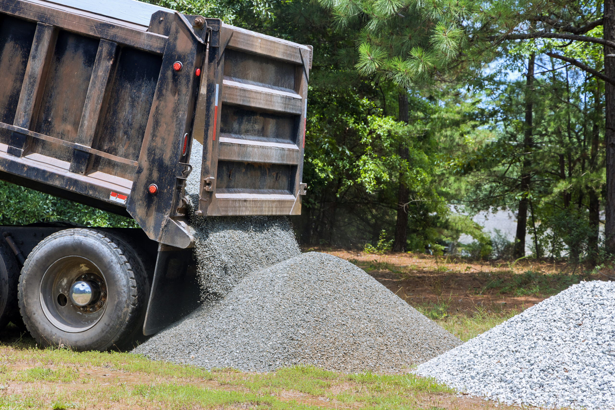 Dump truck hauling sand at construction site in Texas highlighting risks that impact sand and gravel trucking insurance