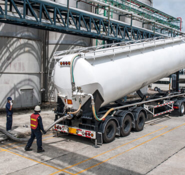 Hazardous materials hauling truck on the road with insurance requirements and cost-saving tips for hazmat carriers